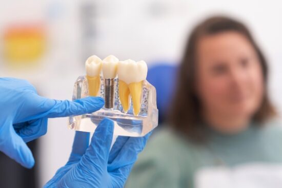 dentist presenting dental implants to woman in treatment chair