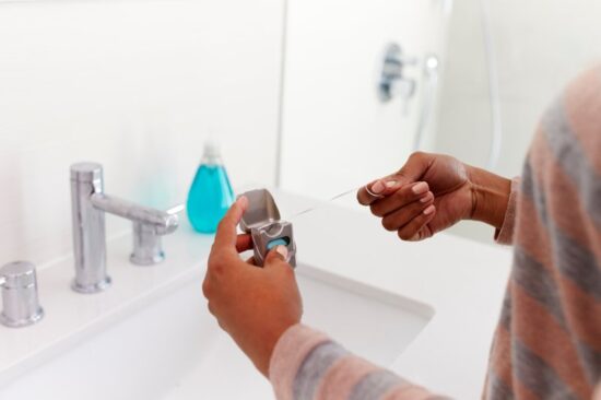 Person pulling out dental floss and wrapping it around their finger.