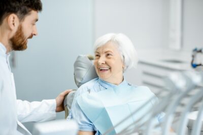 older woman smiling at her dentist