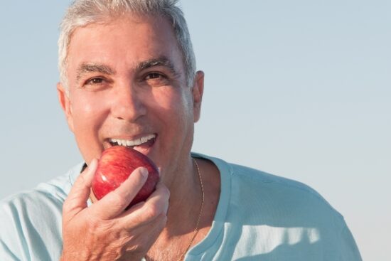 man eating a red apple