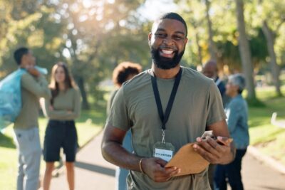 man wearing lanyard and smiling outside