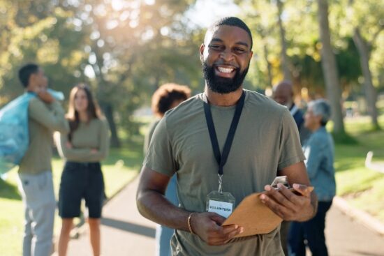 man wearing lanyard and smiling outside