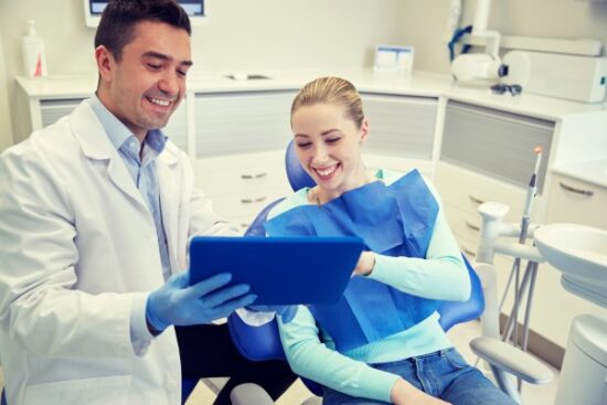 young woman and dentist looking at xrays