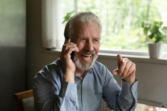 older man on the phone and smiling