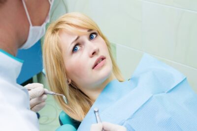 woman with blonde hair afraid in the treatment chair