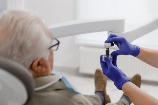 older man looking at a dental implant