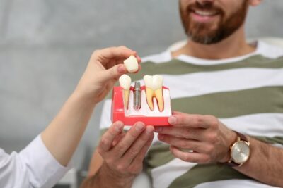 male patient watching dentist show how dental implants work
