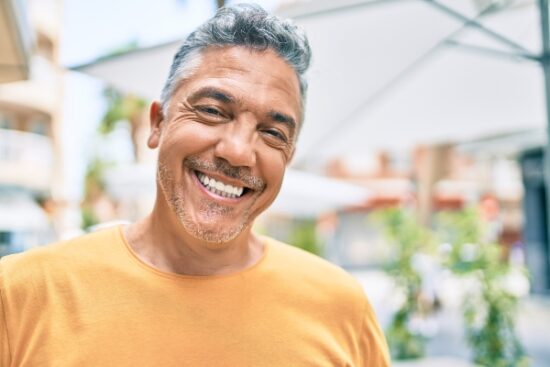 middle-aged man in yellow shirt smiling