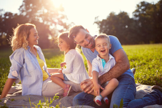 family of four smiling and playing together