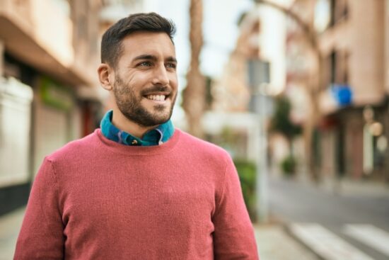 man in a red sweater and smiling outside