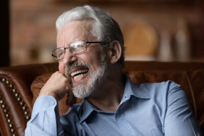 older man with glasses smiling
