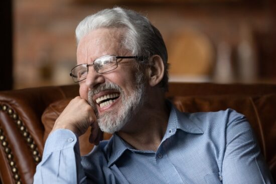 older man with glasses smiling