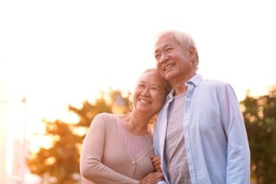 older couple hugging and smiling outside