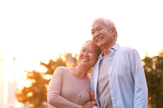 older couple hugging and smiling outside