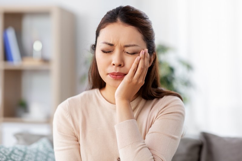 Woman experiencing one-sided jaw pain