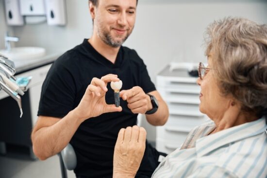 implant dentist talking to elderly female patient