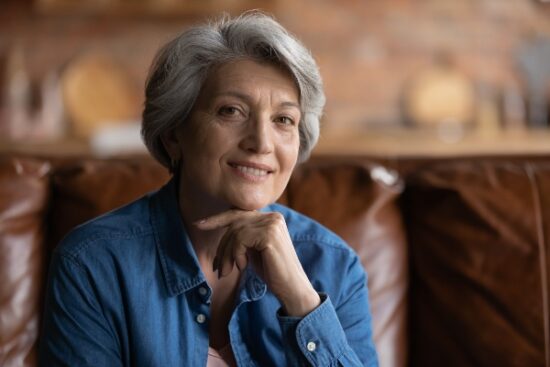 older lady in a blue blouse smiling