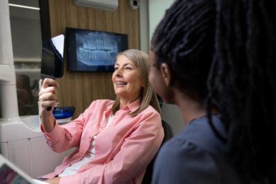 older woman happy with her smile and looking in the mirror