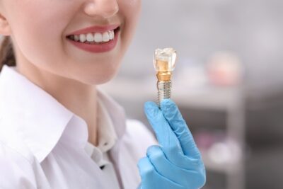 dentist holding a single dental implant