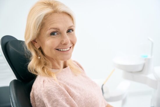older woman smiling in preparation for a dental bridge