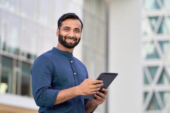 man in a blue shirt and holding a tablet